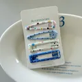 Close-up of four patterned hair clips with polka dots and stripes on a display card - 14# (Blue Striped)
