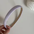 Nahaufnahme eines lavendelfarbenen Satin-Haarreifs mit elegantem, seidigem Finish - Schmales Haarband / Lila
