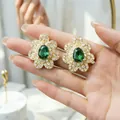 Dettaglio di orecchini a fiore di lusso con pietre verdi a goccia e cristalli. - Solo Orecchini / Verde