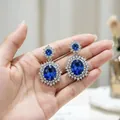 Dettaglio di orecchini di lusso con topazio blu e pavé di cristalli brillanti a cerchio - Orecchini / Blu