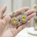 Dettaglio di orecchini pendenti con cristallo giallo e lussuoso alone di diamanti - Orecchini / Giallo