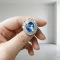 Dettaglio ravvicinato di un anello in argento con topazio blu ovale e diamanti - Anello / Blu