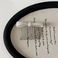 Detailed view of a white acetate bow hair comb with elegant metal tines for styling. - Hair Comb / Silver White Bow Hair Comb