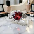 Vista macro di un anello di lusso a forma di cuore con pietra rossa e brillante - Anello / Rosso