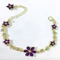 Dettaglio di bracciale floreale dorato con petali in cristallo viola e piccoli fogliami - Viola
