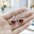 Dettaglio di orecchini a forma di cuore in argento con cristalli rossi e trasparenti. - Orecchini / Rosso