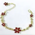 Dettaglio di un elegante bracciale dorato con cristalli floreali rossi e motivi a foglia lucenti - Rosso