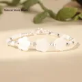 Macro view of white flower shell and jade beads bracelet detail against a soft background - White (Flower Shell Style)