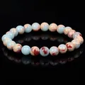 Detailed view of natural amazonite and red jasper beaded bracelet on black surface - Blue Shoushan Stone