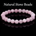 Close-up macro view of a polished pink natural stone beaded bracelet on black surface - 21cm / 10mm / Kunzite Jade