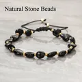 Close-up van onregelmatige zwarte obsidiaanstenen en gouden kralen op geweven armband - Onregelmatige nugget / Obsidiaan Armband