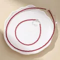 Detail view of faceted red agate bead necklace and bracelet set on a white plate - Necklace And Anklet Set / Ruby