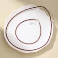 Detail view of faceted red agate bead necklace and anklet set on a white decorative tray. - Necklace And Anklet Set / Red Garnet
