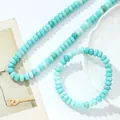 Detail van een ketting en armband set gemaakt van turquoise blauwe crackle kristallen schijfkralen - Ketting + Armband / Amazoniet Kleur