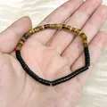 Close-up of natural tiger eye and black cylindrical stone beaded bracelet on hand. - 4x2mm Black Agate Spacer / 19cm Bracelet