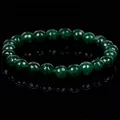 Detail view of deep green faceted crystal beads on a stretch bracelet, macro focus - Faceted Green Gemstone