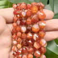 Makro-Detail von facettierten orangefarbenen Achatperlen mit natürlichen Streifen - Facettierte Gedrehte Perlen / 18cm 6mm / Roter Streifenachats