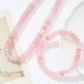 Detalle de cerca del conjunto de collar y pulsera de cuentas de cristal rosa natural - Collar + Pulsera / Rosa Claro