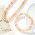 Detalle del conjunto de collar y pulsera de cristal natural color melocotón brillante - Collar + Pulsera / Albaricoque
