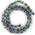 Primo piano di perle di ematite ovali iridescenti con lucentezza metallica per gioielli - 5-8 mm / Verde Lucido
