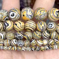 Close-up of yellow natural stone round beads with black and white swirl patterns - 6mm (Approx 58 Pieces/Pack) / Synthetic Yellow Peacock Stone