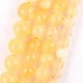 Detailed macro shot showing the natural texture of yellow stone round beads for jewelry - 6mm (Approx. 58 Pieces) / Yellow Rutilated Quartz Chalcedony
