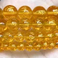 Macro detail of yellow translucent beads with engraved gold mantra symbols for jewelry DIY - 6mm (Approx 58 Pieces/Pack) / Yellow Six-Character Mantra
