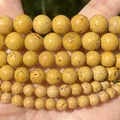Macro detail of yellow natural stone round beads showing unique texture for DIY jewelry - 6mm (Approx. 58 Pieces) / Grass Flower Stone Yellow