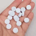 Close-up of small white circular foam pads for jewelry packaging in a person's hand - Pack of 200 / Eco White