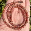 Detailed view of 5x12mm bamboo-shaped natural red agate beads for DIY jewelry making - One Strand Approx 31 Pieces (5x12mm) / Red Sesame Stone
