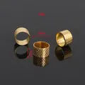 Close-up macro detail of golden metal sewing thimble with 18mm measurement labels - Sewing Thimble