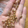 Close-up of 18K gold plated flat rondelle spacer beads held in hand for DIY jewelry - 5.8mm / Gold