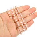 Close-up detail of light pink pearl chain with gold-plated links held in human hand. - Artificial Pearl Chain (1 Meter) / Gold