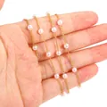 Detailed macro view of an 18K gold-plated chain with delicate acrylic pearls in hand. - Artificial Pearl and Chain (1 Meter) / Gold