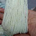 Close-up of multiple strands of white ABS imitation pearls for DIY jewelry making. - Hole-less Round Beads / 6mm 100 Pcs / Off White