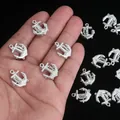 Detail of silver anchor charms for DIY jewelry making shown on hand for size reference - Anchor / 100pcs Pack