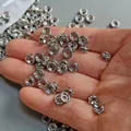 Gedetailleerd beeld van 6mm zilveren rondelle tussenkralen met zirkonen in de hand - 6MM Zirconia Ingelegde Afstandskraal / Witgoud verguld koper