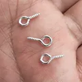 Small silver metal eye screw pins for DIY jewelry making shown on a human palm scale - 8x4mm / Silver