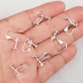 Silver plated screw-on earring clip converters for non-pierced ears shown on hand - Round Plate Screw Style / 1 Piece / Silver