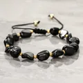 Close-up of black tourmaline stone bracelet with gold bead spacers and braided cord - Black Tourmaline Gravel Style / Adjustable Braided Rope / Black