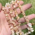 Macro view of bohemian natural chip shell beads in peach and white for DIY jewelry - Single String / Off White