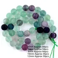 Detailed macro view of natural colorful fluorite beads in various green and purple hues - Round Bead (Matte) / 4mm (Approx 88pcs/strand) / Matte Rainbow Fluorite