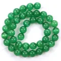 Macro dettaglio di vivaci perline in pietra occhio di gatto verde, perle tonde lucide per gioielli - Verde