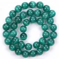 Primo piano di perle tonde in occhio di gatto verde scuro lucido per la creazione di gioielli - Verde scuro