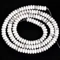 Vue macro de perles de howlite blanche naturelle avec veines grises pour création de bijoux - Style rondelle naturelle / 2x4mm