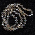Detailed macro shot of 6mm faceted champagne flower glass beads for DIY jewelry crafts. - Four-Leaf Flower Shape / One Strand (6mm) / Light Champagne