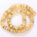 Macro view of yellow Trochus shell disc beads with center hole for jewelry making - 10-11mm Pack (Approx 200 Pieces) / Yellow