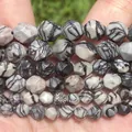 Close-up of faceted natural stone beads with unique black and white patterns - 6mm Approx 58 Pieces / Faceted Black Network Stone