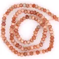 Nahaufnahme von facettierten 3x4mm pfirsichfarbenen Natursteinhöhlen für DIY-Schmuck - 3x4mm (Ca. 105 Stück/Strang) / Sonnenstein-Jade
