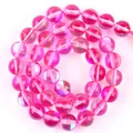 Close-up of rose red translucent round glass beads in a spiral arrangement - 6mm (Approx 58 Beads) / Rose Red Flash Stone